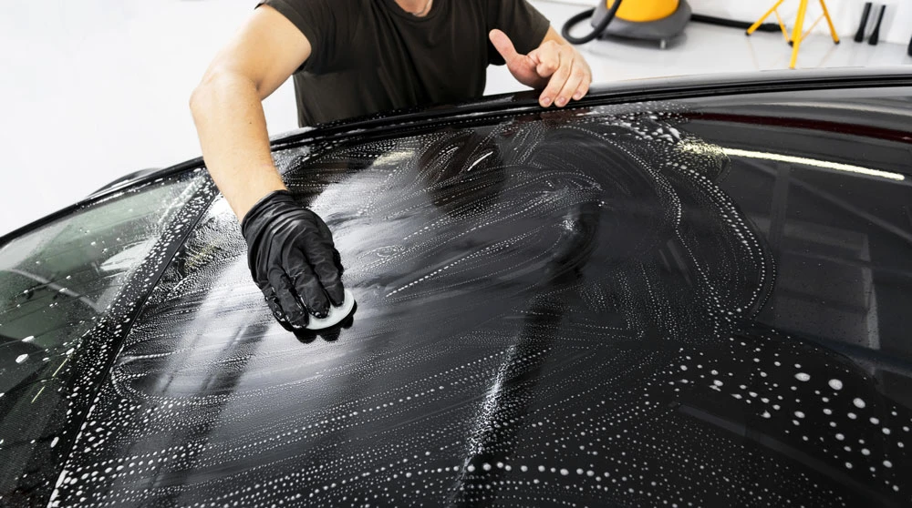 Using a clay bar to remove contaminants from the car's surface.